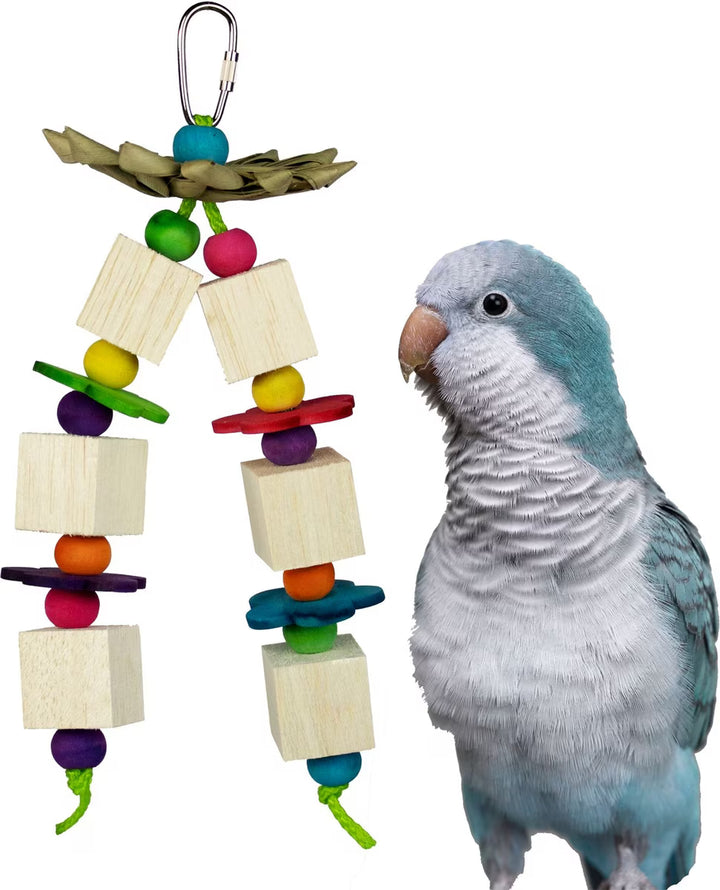 Colorful bird toy with wooden blocks and beads next to a parrot on a white background