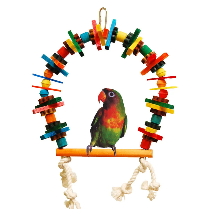 A colorful wooden parrot toy arch with a natural wood perch and white rope hanging below, shown on a plain white background with a small green and red parrot perched in the center -Zoo-Max Block Bird Perch 6"